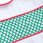 Close-up of a white garment with green and red patterns