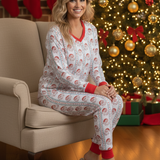 Woman in pajamas sitting on a chair in front of a decorated Christmas tree.